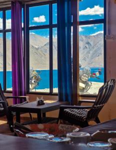 a room with a view of a mountain through a window at pangong rainbow cottage in Lukung