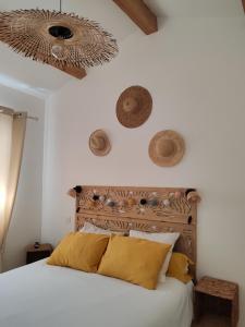 a bedroom with a large white bed with yellow pillows at Au Cabanon in Saint-Laurent-dʼAigouze