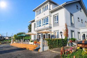 a white building with umbrellas in front of it at Hotel Capellan in Navia +36 photos