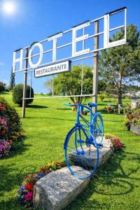 a blue bike statue in front of a sign at Hotel Capellan in Navia