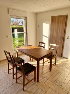 a wooden table and chairs in a living room at FeWo Am Feldrand in Prebberede