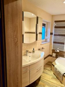 a bathroom with a sink and a mirror at FeWo Am Feldrand in Prebberede