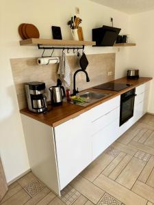 a kitchen with a sink and a counter top at FeWo Am Feldrand in Prebberede +19 photos