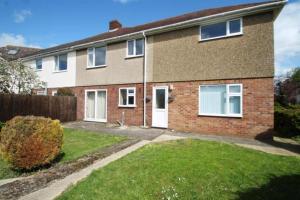 a brick house with a white door and a yard at Sawston Village in Sawston