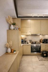 a kitchen with wooden cabinets and a stove at Vouliagmeni Sunset Veranda in Athens