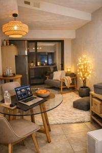 a living room with a table with a laptop on it at Vouliagmeni Sunset Veranda in Athens