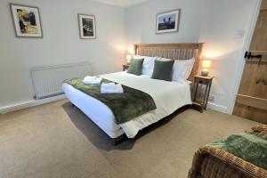 a bedroom with a large bed with two towels on it at Phoenix Cottage, Bakewell in Bakewell