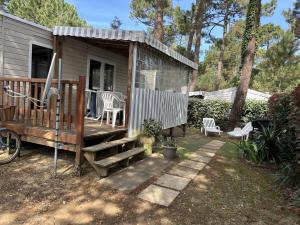a tiny house with a porch and a deck at Mobil Home 6 personnes camping 4 etoiles Bonne Anse la Palmyre in Les Mathes