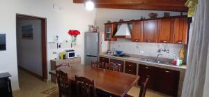 a kitchen with wooden cabinets and a wooden table with a sink at Lampedusa da Sogno 1 in Lampedusa