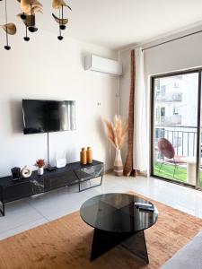 a living room with a black coffee table and a large window at Résidence Uria in Libreville