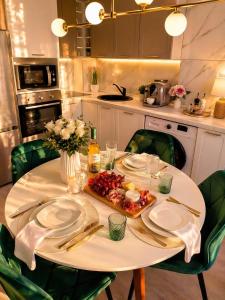 a white table with a plate of food on it at Emerald Apartment On Arena Oradea in Oradea