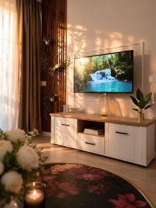 a living room with a tv on a wall at Emerald Apartment On Arena Oradea in Oradea