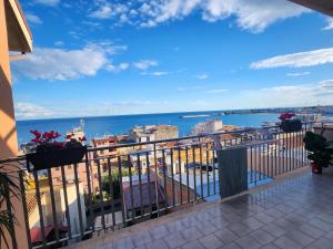 a balcony with a view of the ocean and buildings at Serenity Naxos Vacation Home in Giardini Naxos