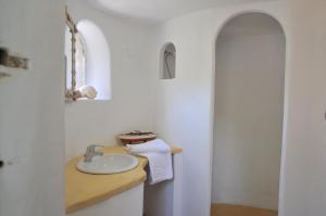 a white bathroom with a sink and a mirror at Résidence Les Mandiles in Cargèse +114 photos