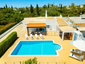 a villa with a swimming pool and a house at Villa Solara - com piscina aquecível e BBQ em Carvoeiro in Carvoeiro