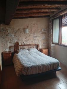 a bedroom with a bed in a stone wall at CASA VICENT in Valderrobres