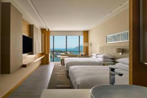 a hotel room with two beds and a television at Kota Kinabalu Marriott Hotel in Kota Kinabalu