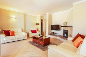 a living room with white furniture and a fireplace at Villa Solara - com piscina aquecível e BBQ em Carvoeiro in Carvoeiro