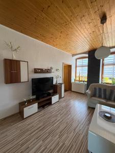 a living room with a couch and a flat screen tv at Fewo zum Klosterhof EG 1 in Schwanebeck