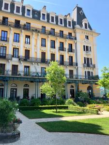 a large yellow building with a tree in front of it at Studio 329 in Aix-les-Bains