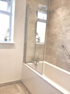 a bathroom with a shower with a tub at The Meadows, OXTED in Tandridge +15 photos