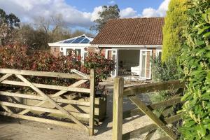 a white house with a wooden fence in front of it at The Meadows, OXTED in Tandridge