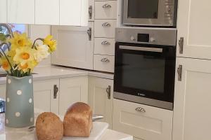 a kitchen with a vase of flowers and some bread at The Meadows, OXTED in Tandridge