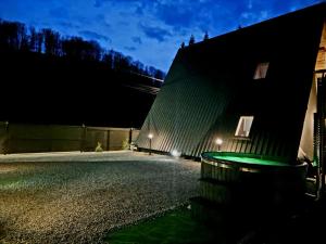 a building with a green roof at night at Zori de zi in Lupeni