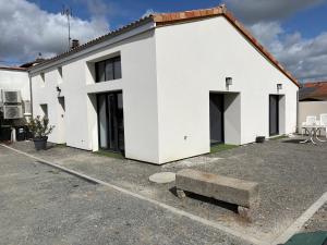 a white house with a bench in front of it at La Claverie in Cholet