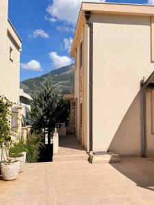 a walkway between two buildings with mountains in the background at Villa del Mare in Dobra Voda