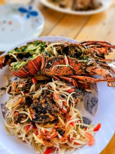 a plate of food with seafood and pasta on a table at L'île de Marie-Jo in Assinie