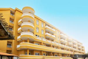 a yellow apartment building with white balconies at Villa De Adeje Beach in Adeje
