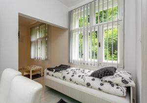 a bedroom with a bed and two windows at Vila Cirkovic - 200m od mermernog setalista in Soko Banja