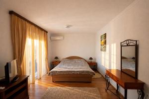 a bedroom with a bed and a desk and a mirror at Villa del Mare in Dobra Voda