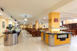 a restaurant with tables and chairs and a buffet at Villa De Adeje Beach in Adeje