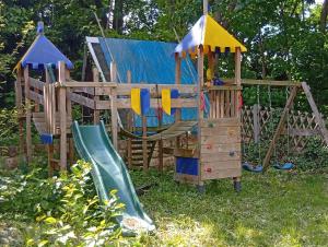 a wooden playset with a slide and a slideintend at FEWO Radebeul Am Waldrand Spittelholz in Radebeul