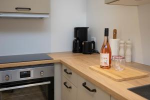 a kitchen counter with a bottle of wine and a glass at Lønstrup Apartments, Klitrose in Lønstrup +4 photos
