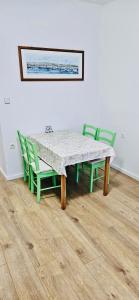 a table and chairs with a table and a painting on the wall at Apartments Porat in Porat
