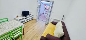 a room with a couch and a television and a table at Apartments Porat in Porat