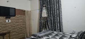 a bedroom with a bed with a black and white curtain at Home stays 1bhk in Jammu