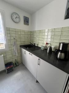 a kitchen with a sink and a clock on the wall at Fachwerkjuwel im Bergischen in Remscheid +5 photos