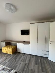 a living room with white cabinets and a yellow couch at Apartmani Zeleni Horizont in Bratunac