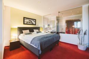 a bedroom with a large bed and a large mirror at Hotel Restaurant Pusswald in Hartberg