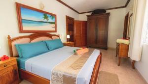 a bedroom with a large bed and a table at Villa Bel Age Seychelles in Anse Royale +31 photos