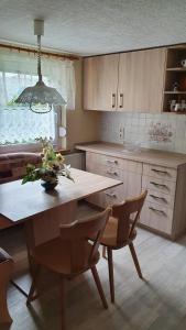 a kitchen with a table and chairs and a dining room at Ferienhaus Bringfriede in Muldenhammer