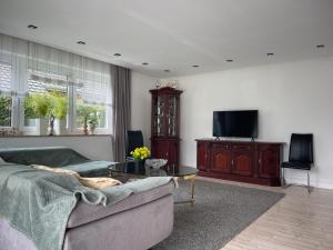 a living room with a couch and a tv at Ferienwohnung Lilienthal in Lilienthal
