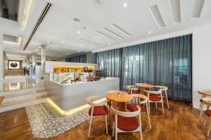 a restaurant with tables and chairs and a counter at BelAire Bangkok Sukhumvit in Bangkok