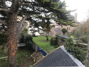 a view of a yard with a tree and a house at Poutres et charme in Paimpol