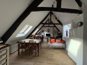 a room with a table and chairs in a attic at Poutres et charme in Paimpol
