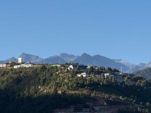 a town on a hill with mountains in the background at E-RE House, Dirang in Dirang Dzong